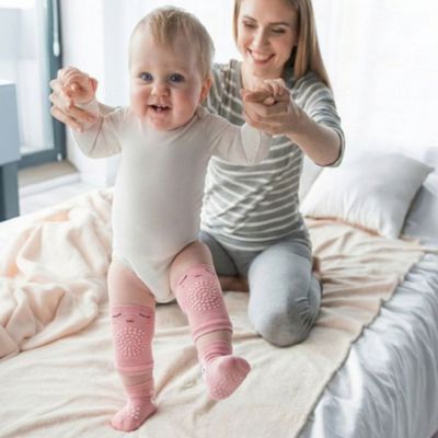 Genouillères pour bébé avec chaussettes bébé jouant avec maman