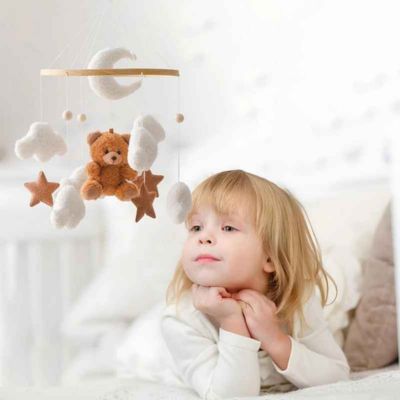 Mobile bebe ourson marron petite fille regarde l'ourson