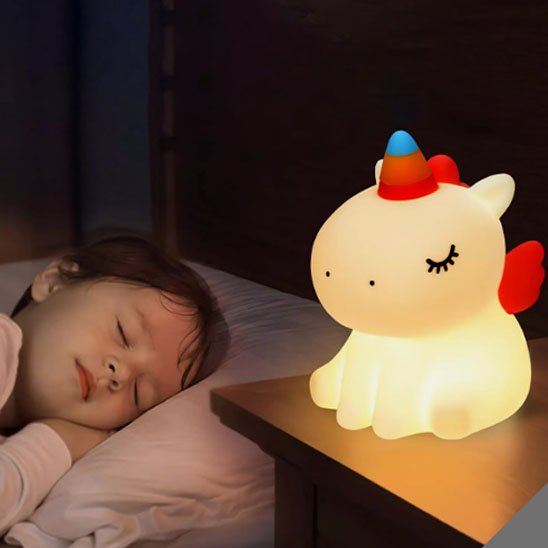 Bébé endormi près d’une veilleuse bébé licorne lumineuse