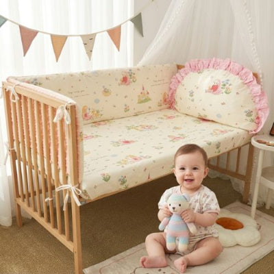 tour de lit bébé coton 4 pièces bébé qui joue avec une peluche